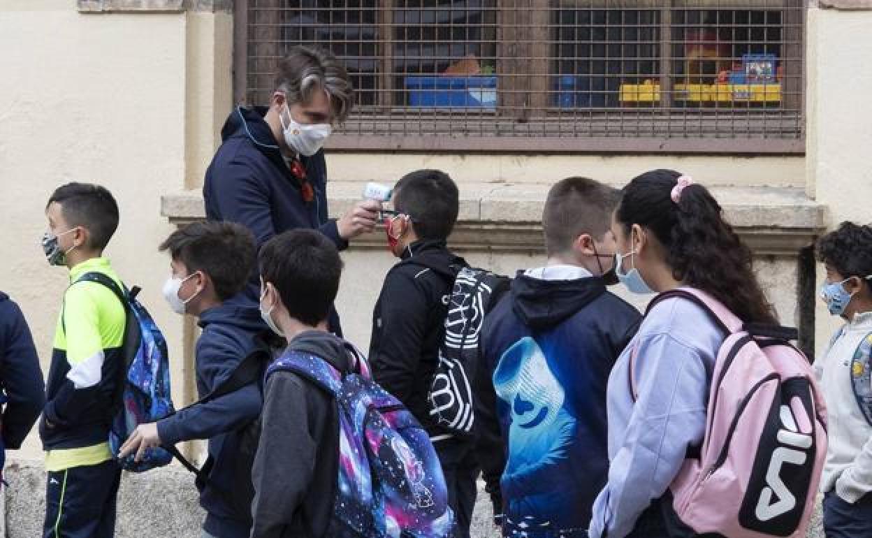 Un docente realiza un control de temperatura a los alumnos de un colegio. 