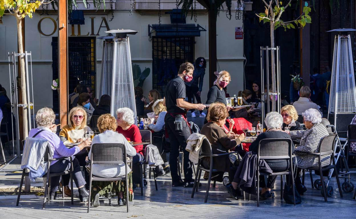 Un camarero atiende una terraza de la plaza Cardenal Belluga de Murcia, en una foto de la pasada Navidad.