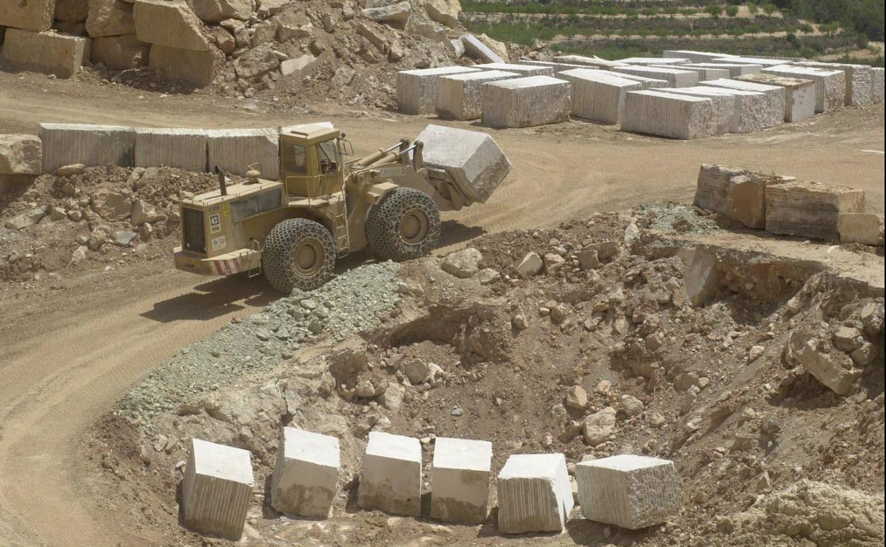 Un tractor transporta un bloque de mármol en una cantera de la Región.