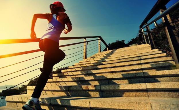 Una mujer sube unas escaleras corriendo.