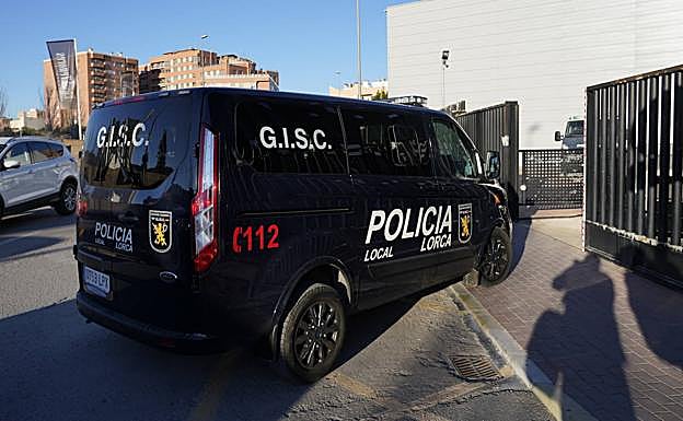 Un vehículo de la Policía Local de Lorca traslada a la comisaría de la Policía Nacional al arrestado por agredir a un agente durante el asalto al Pleno de Lorca.