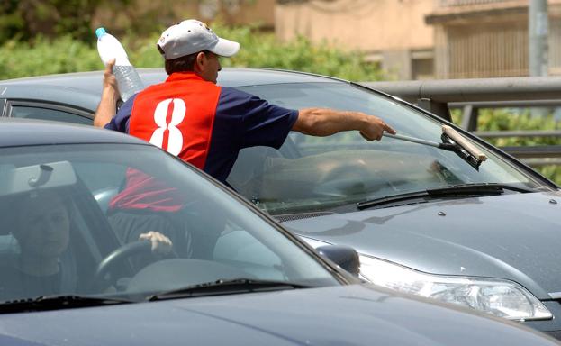 Un hombre limpia el parabrisas de un coche, en una imagen de archivo.