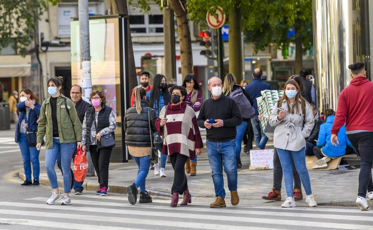 Varias personas, la mayoría con mascarilla, caminan por el centro de Murcia. 