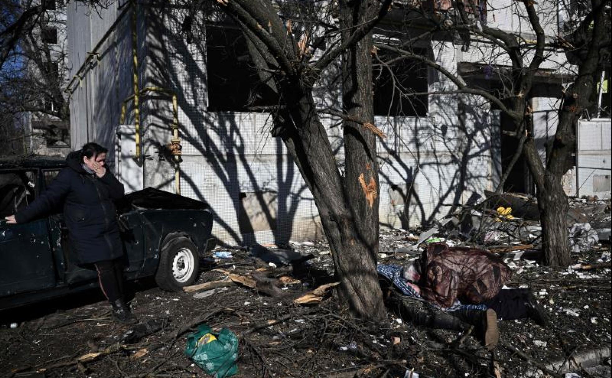 Dos personas lloran la muerte de una persona tras el bombardeo en la ciudad ucraniana de Chuguev.