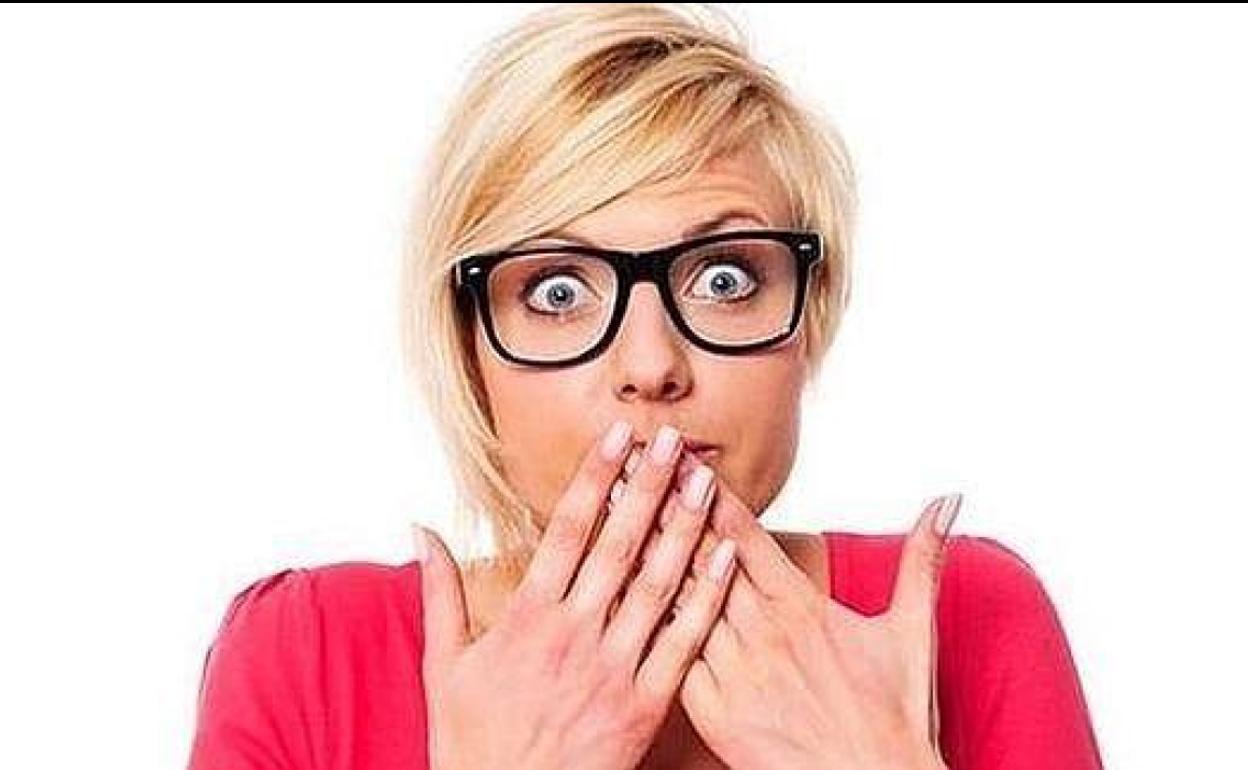 Una mujer se tapa la boca ante un ataque de hipo.