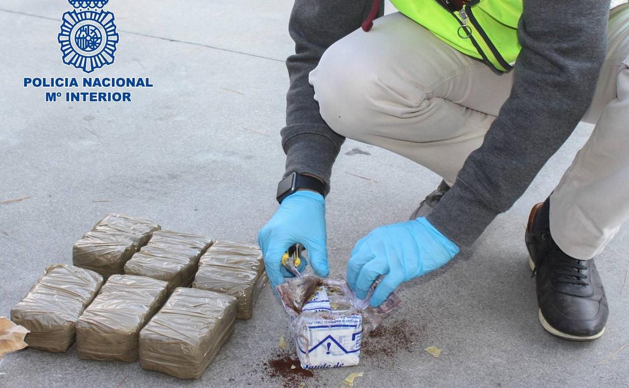 Un agente de la Policía Nacional junto a la droga encontrada. 