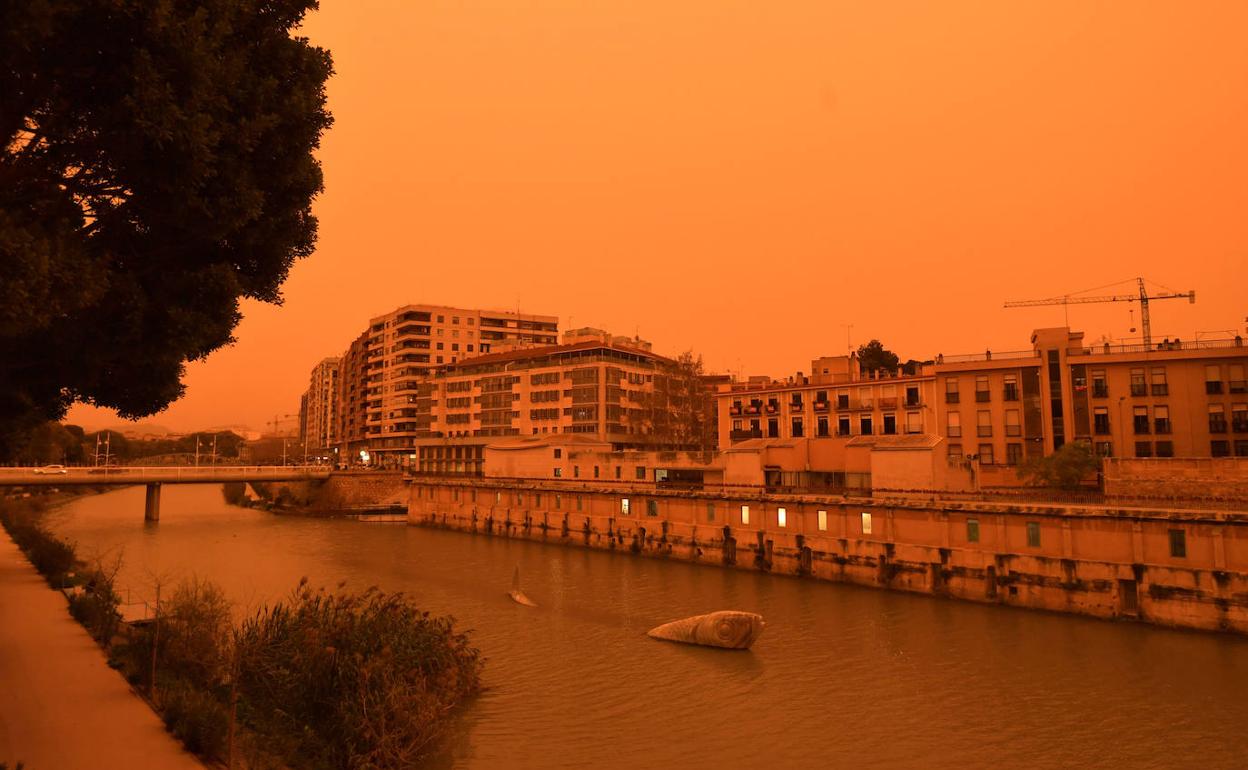 Imagen del río Segura, a su paso por Murcia, cubierto por una atmósfera naranja, el pasado lunes.