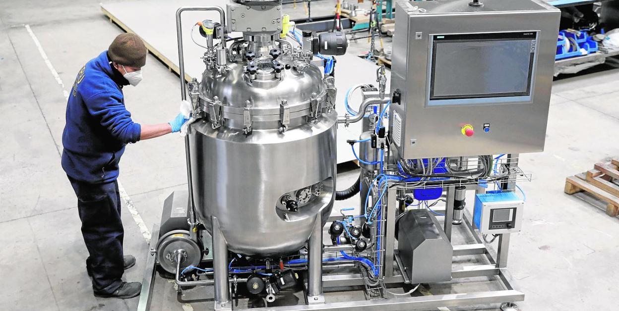 Un técnico limpia una máquina antes de su instalación en una nave industrial. 