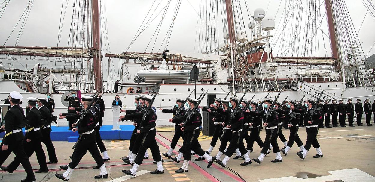 Desfile de la compañía mixta de la Armada, en la Terminal de cruceros Juan Sebastián Elcano, al final de la ceremonia, con el buque escuela al fondo minutos antes de zarpar. 