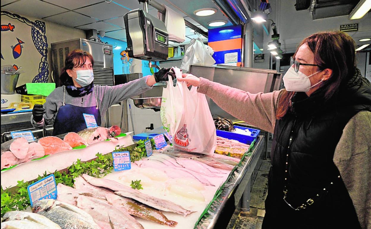 Carmen Macanás recibe su encargo en la pescadería. 