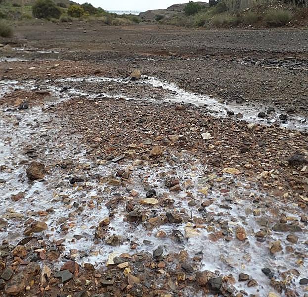 Reguero de residuos en Llano del Beal, con el Mar Menor al fondo.