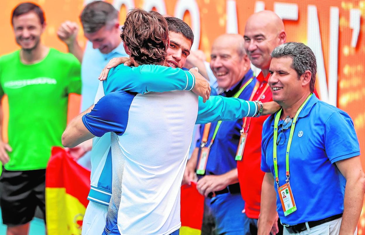 Alcaraz abraza a Ferrero, en presencia de su padre, a la derecha, en la ceremonia de entrega de trofeos. 