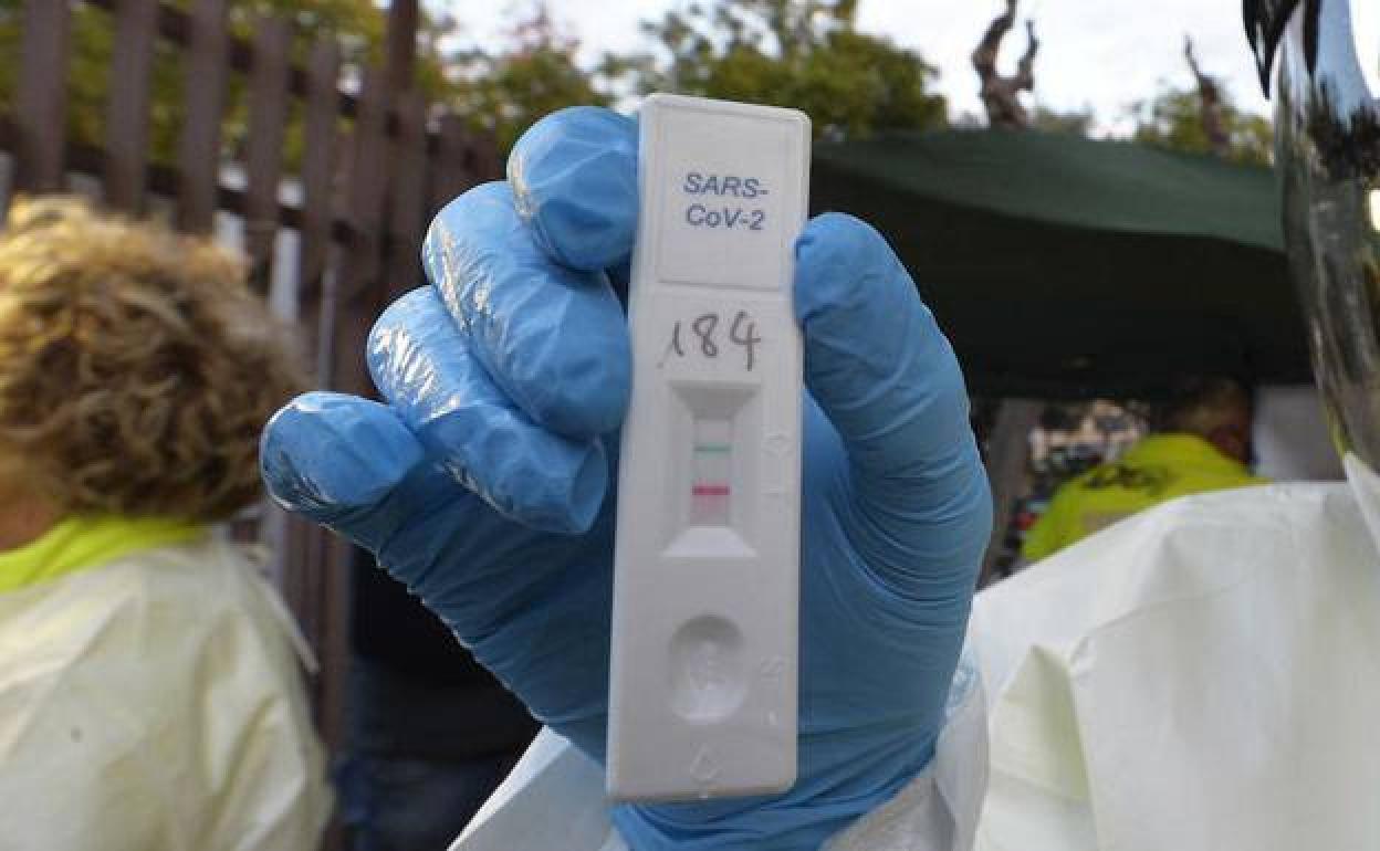 Un sanitario muestra un test de antígenos positivo, en una imagen de archivo.