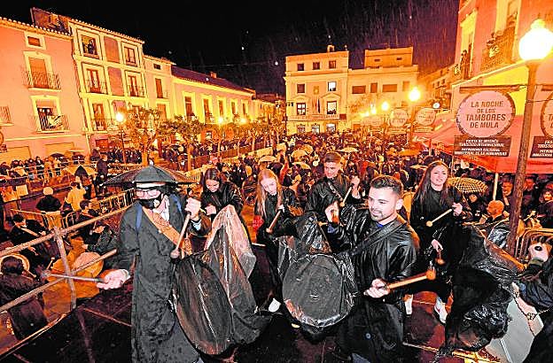 El público abarrotó la plaza del Ayuntamiento de Mula para participar en la tamborada pese a que el tiempo no acompañó. 