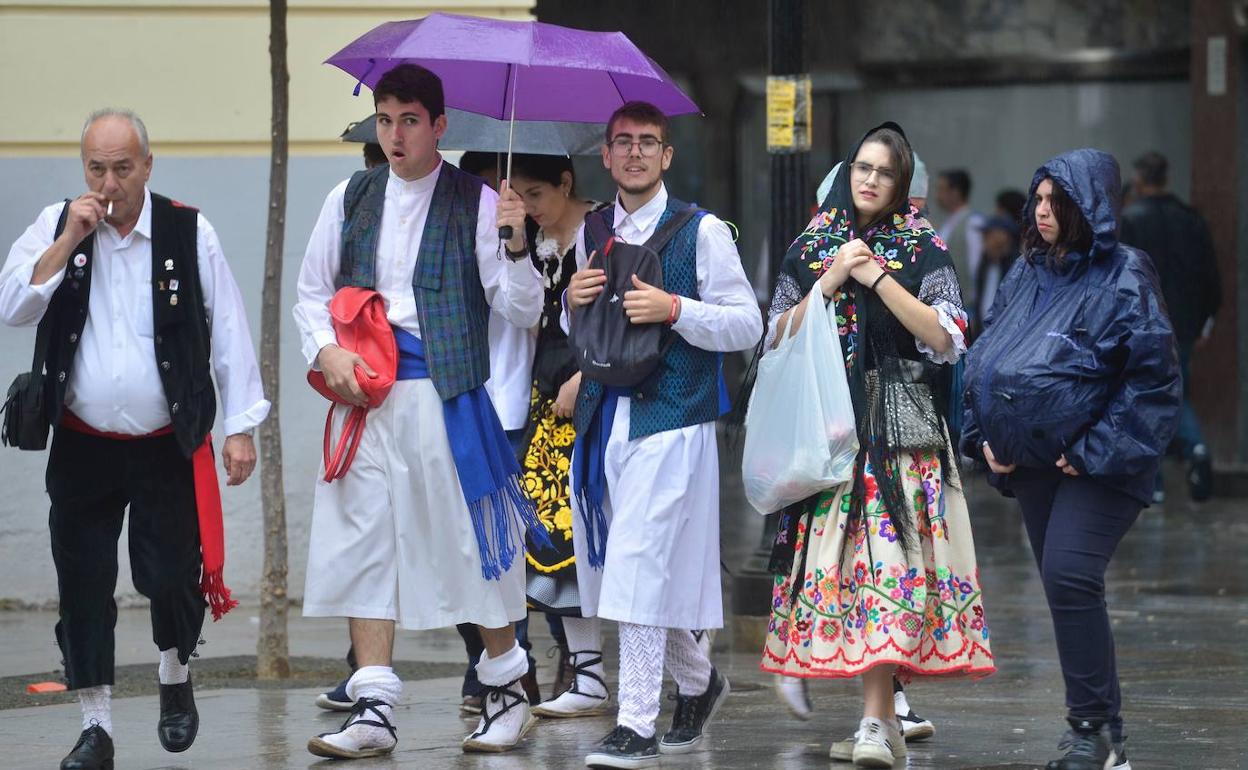 Viandantes con paraguas se protegen de una fina lluvia, en el Bando de la Huerta de 2019.