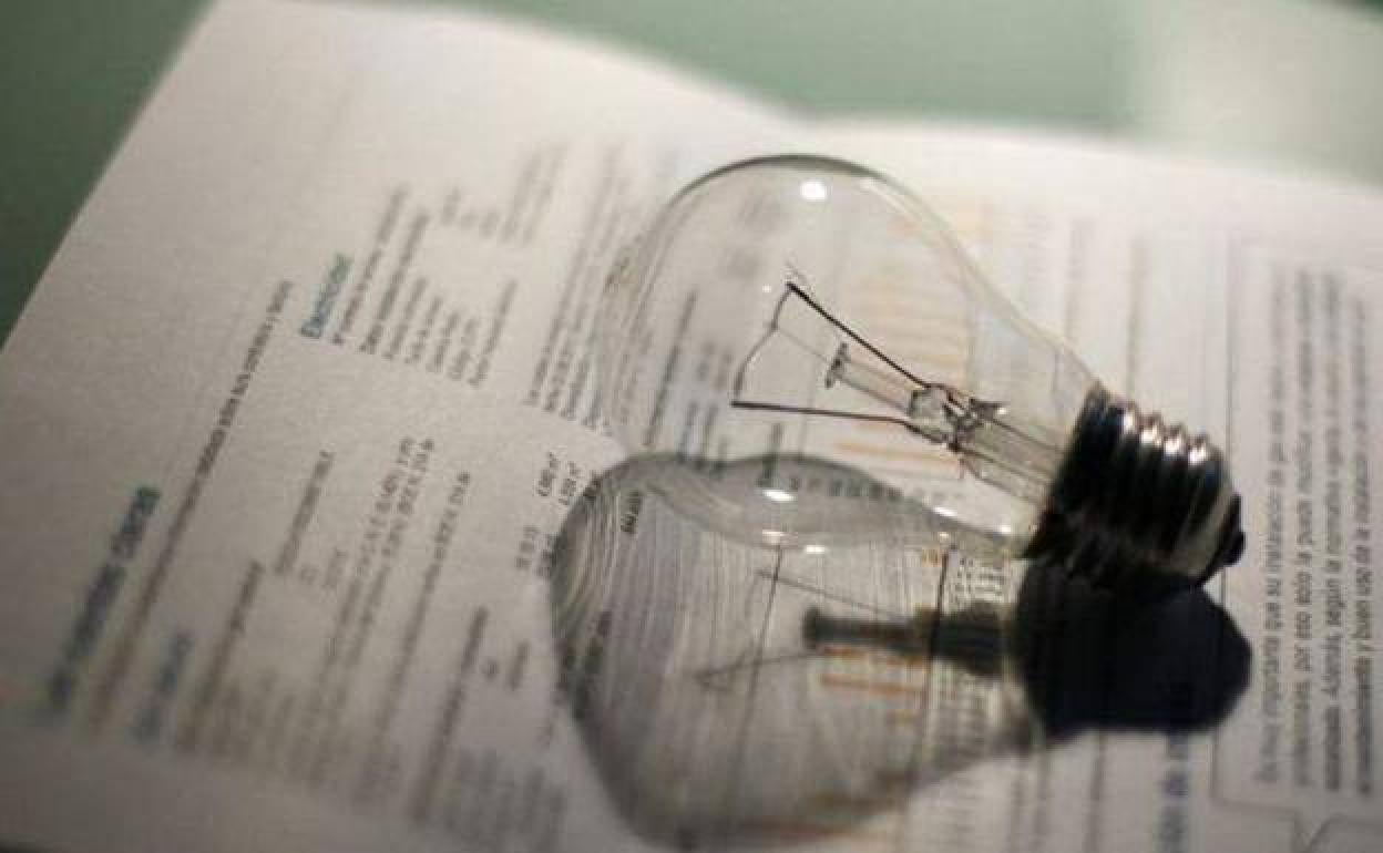 Bombilla sobre una factura de la luz