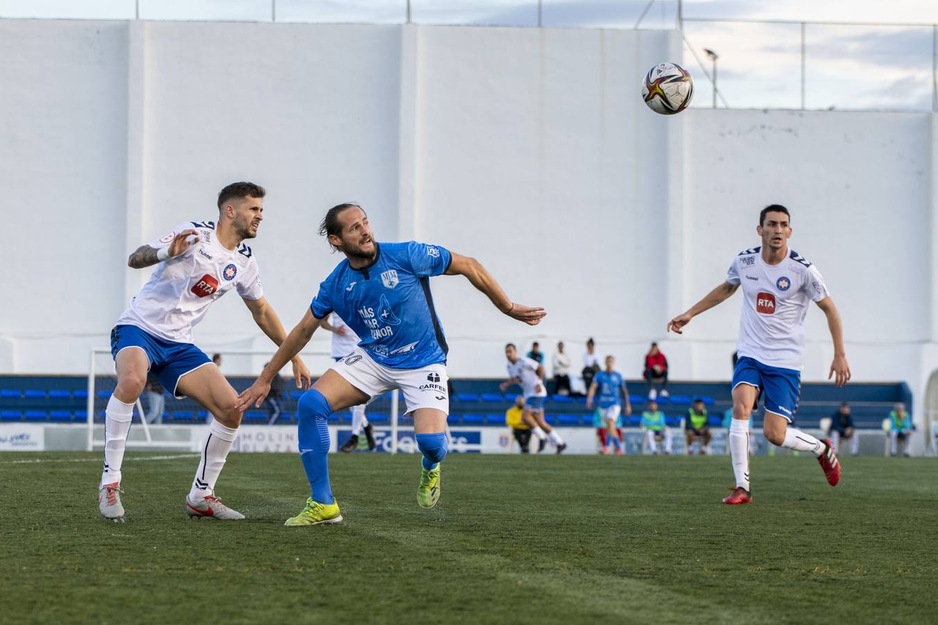 Titi, del Mar Menor, entre dos jugadores del Puertollano. 