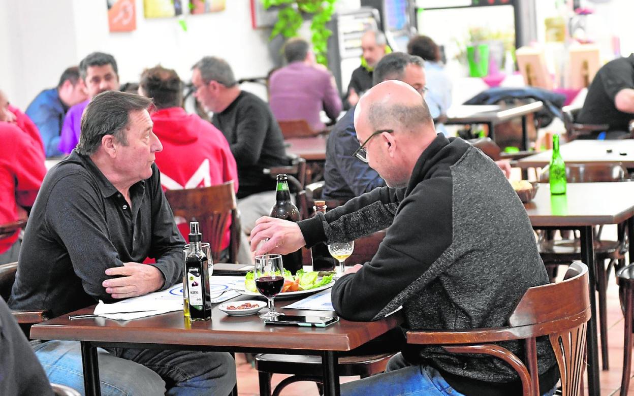 Dos hombres comen, con vino, en un restaurante de Murcia. 