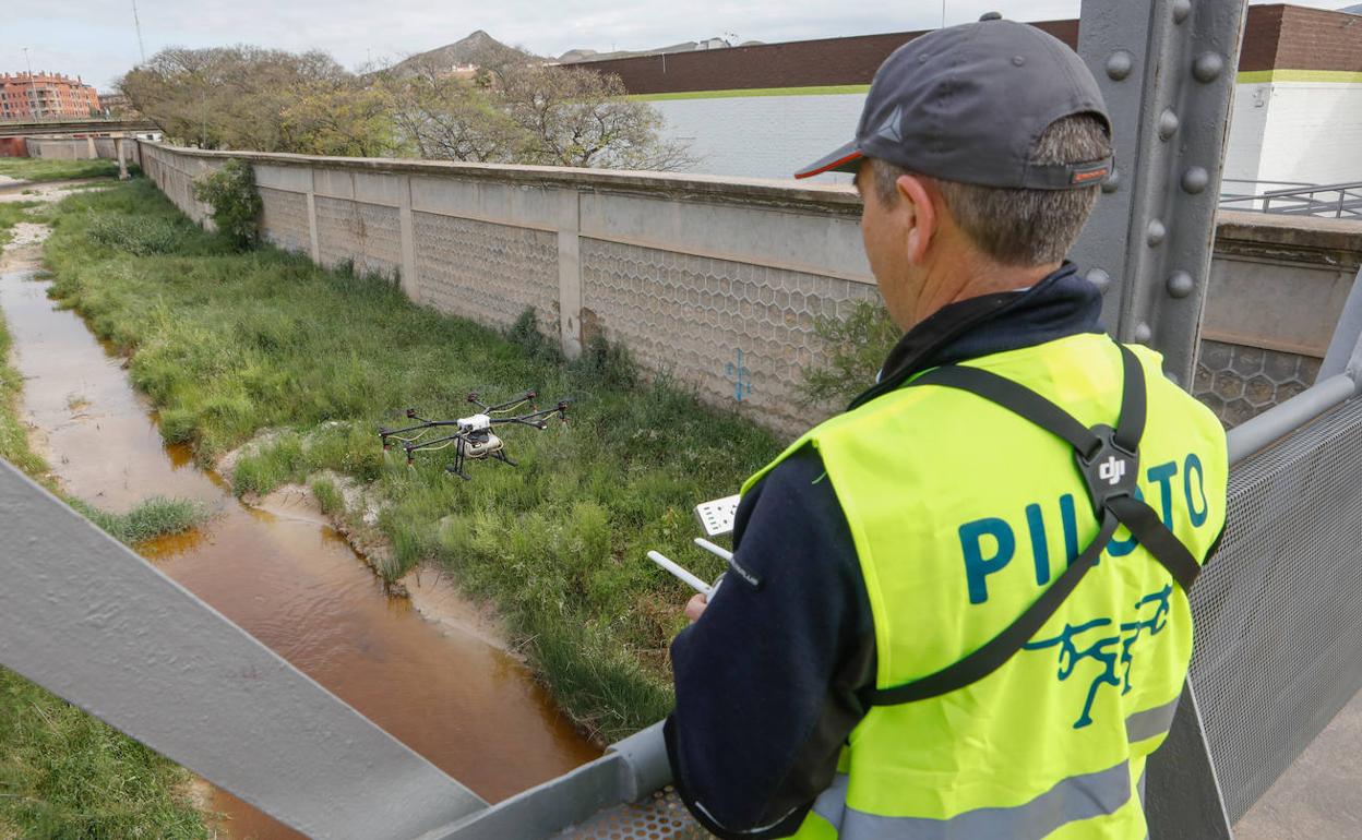 Personal técnico de la empresa de control de plagas maneja el dron que sobrevuela el río.