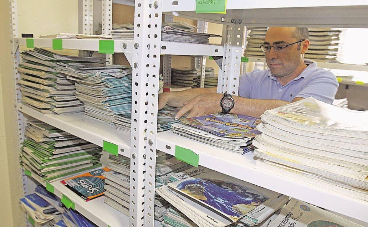 Un trabajador en un banco de libros en un colegio de Torre Pacheco. 