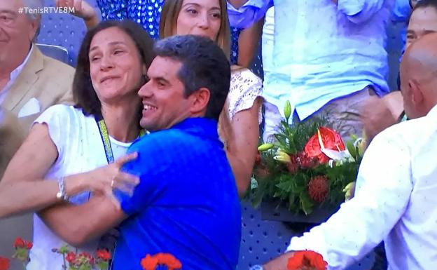 Imagen principal - Los padres de Carlos Alcaraz, Virgina y Carlos, se abrazan en el palco tras el último punto que proclamó a su hijo campeón del Mutua Madrid Open, ayer en la Caja Mágica. | Los pilotos Marc y Álex Márquez aplauden en la primera fila del palco; Fernando López Miras, en la tercera, hace lo mismo. | Todos los miembros del equipo de Carlos Alcaraz, con Juan Carlos Ferrero y Albert Molina en el centro, junto a varios trabajadores de la Academia Equelite de Villena. 