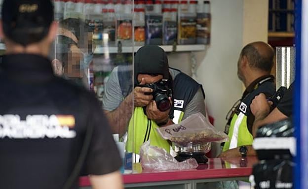 Un agente de la Policía Nacional fotografía el material incautado en una nave en el polígono de San Ginés, en Alcantarilla.