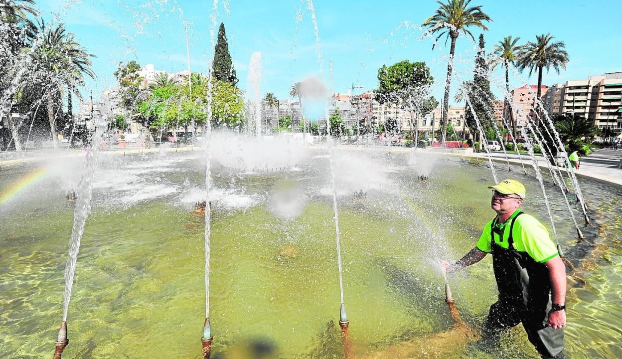 Un operario de STV retira el cloro que se incrusta en los tubos de salida de la fuente de la plaza Circular. 