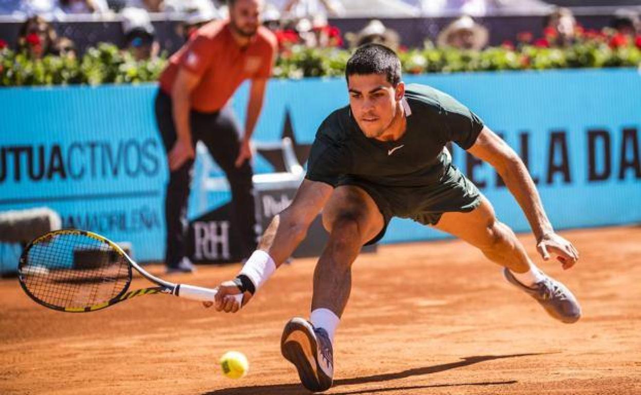 Carlos Alcaraz intenta golpear una bola en el partido de semifinales ante Novak Djokovic en el Mutua Madrid Open.