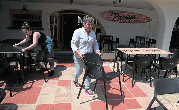 Belén Romero (d) coloca las mesas de su restaurante de Cabo de Palos con la ayuda de una de sus empleadas. 