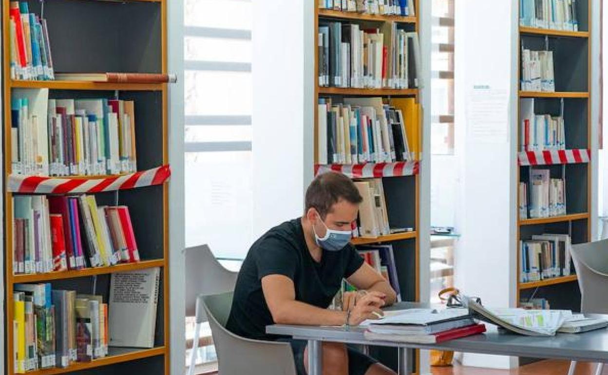 Un joven estudiando en una biblioteca