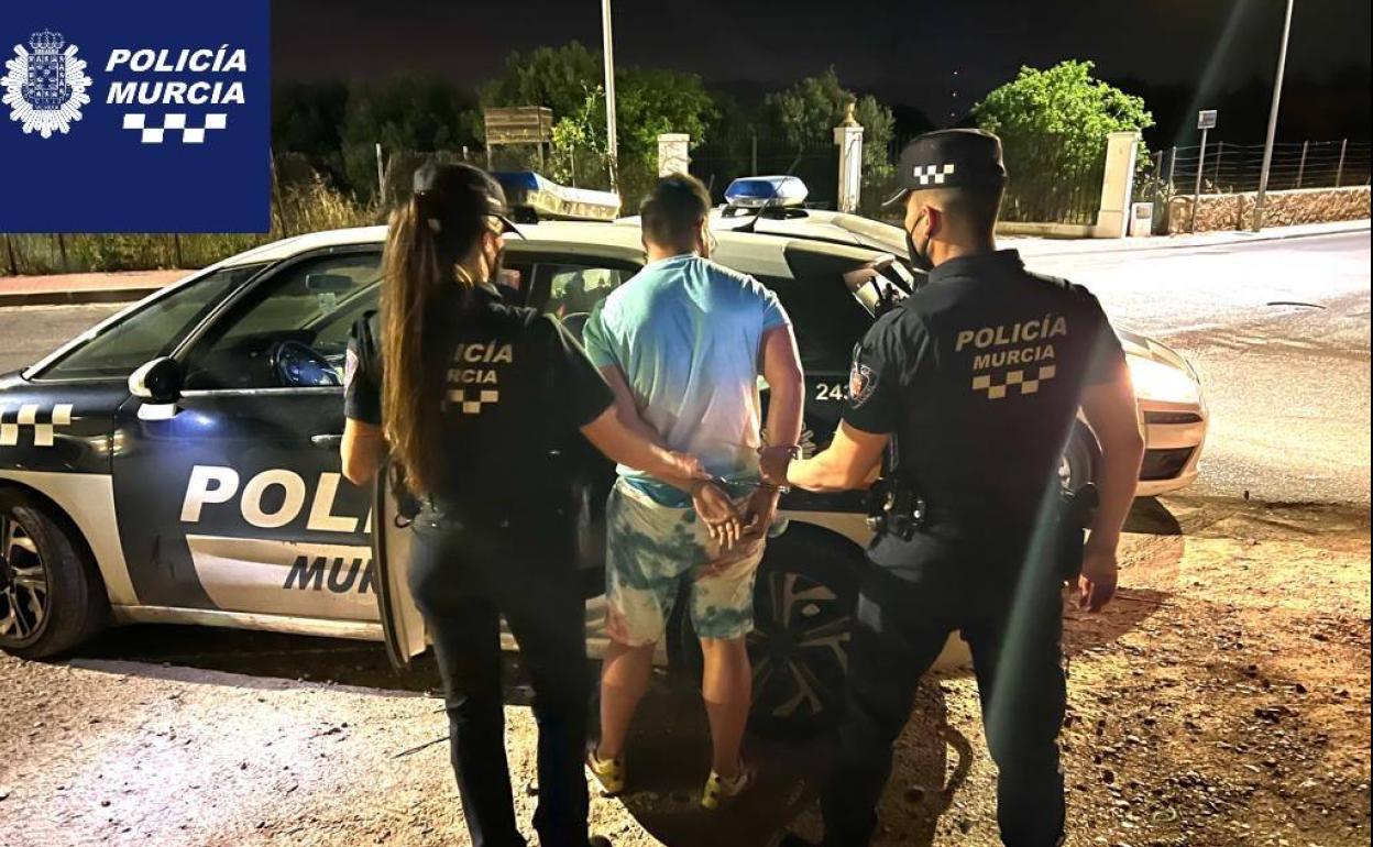 Dos agentes detienen al presunto delincuente.