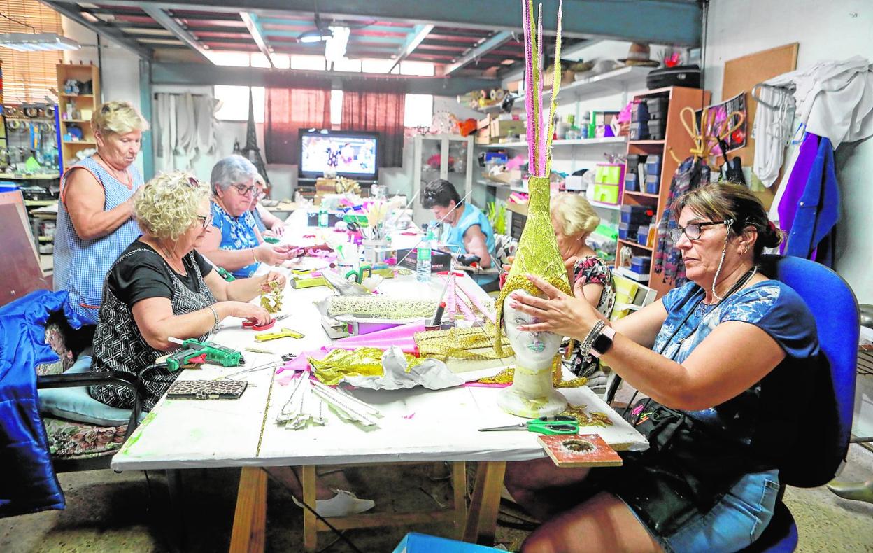 Un grupo de mujeres prepara los trajes de papel para el Carnaval de Águilas, que se celebrará a finales del próximo mes de julio. 