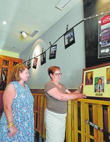 Imagen secundaria 2 - A la izquierda, Inés Lorca y Pepe Flores en la barra del primer local de El Secretario; a la derecha, sus hijas Loren y Conchi muestran fotos del bar que abrió su abuelo en 1916. 