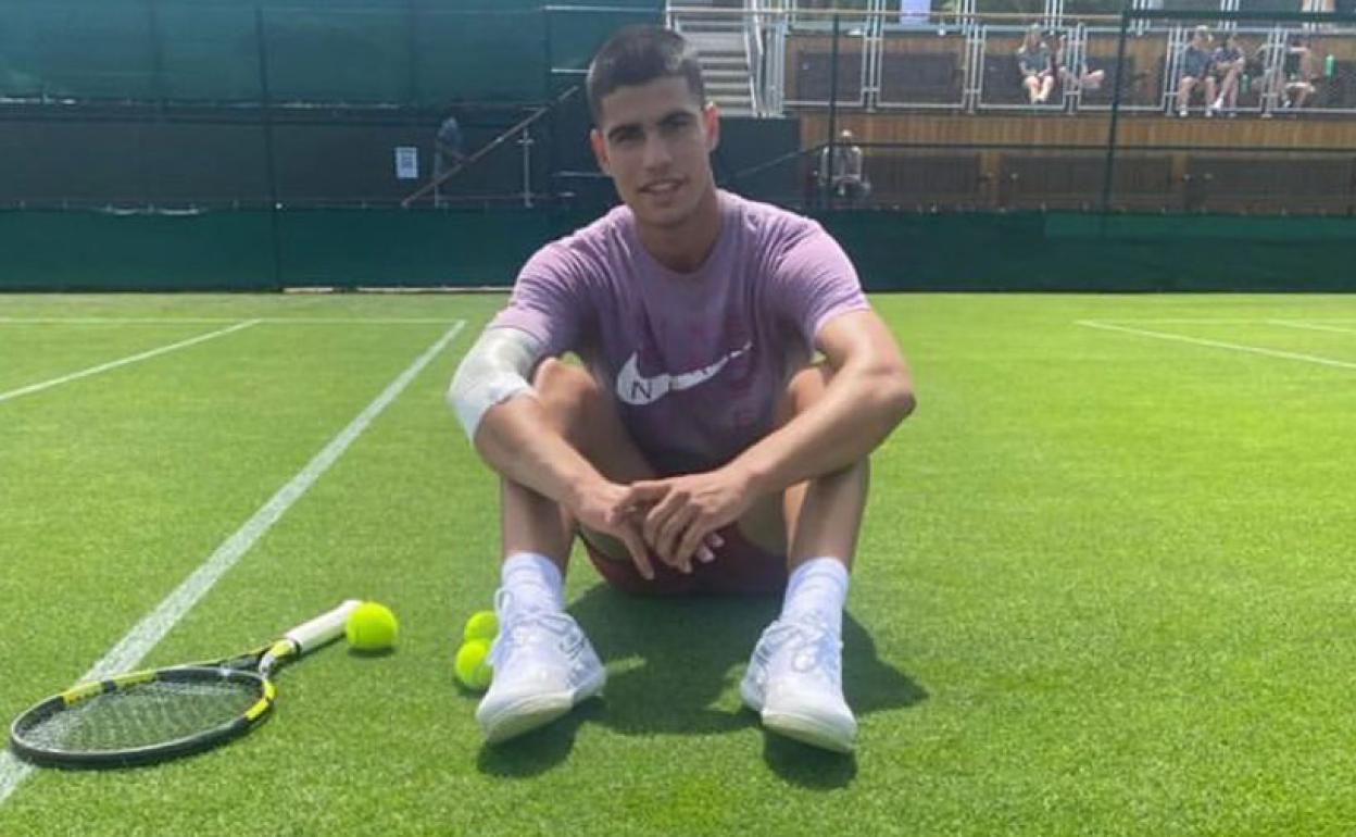 Carlos Alcaraz posa sentado en una cancha de Wimbledon, ayer. 