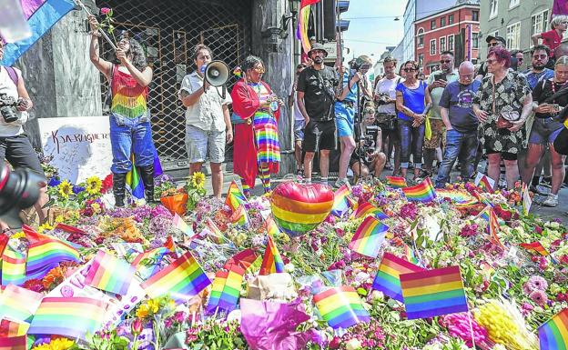 Una multitud de personas protestan por el atentado en un pub gay que acabó con la vida de dos personas, a las que se les dedicó una ofrenda floral.