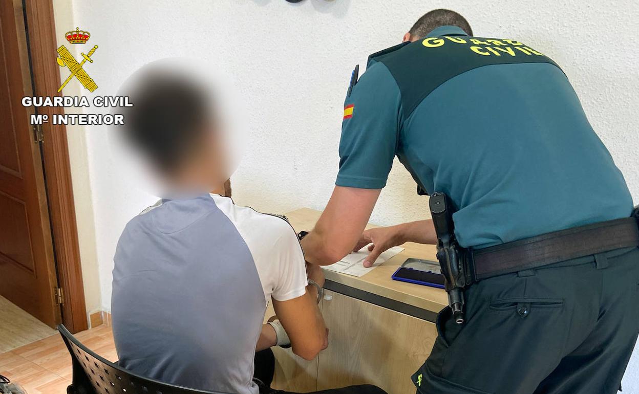 Un agente de la Guardia Civil junto a uno de los jóvenes detenidos.