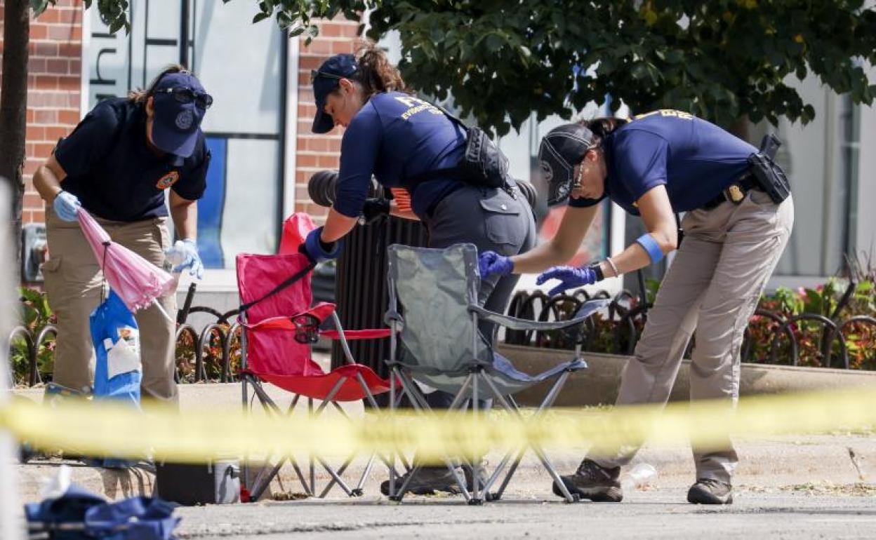 Agentes recuperan pruebas en el lugar del tiroteo en Highland Park. 