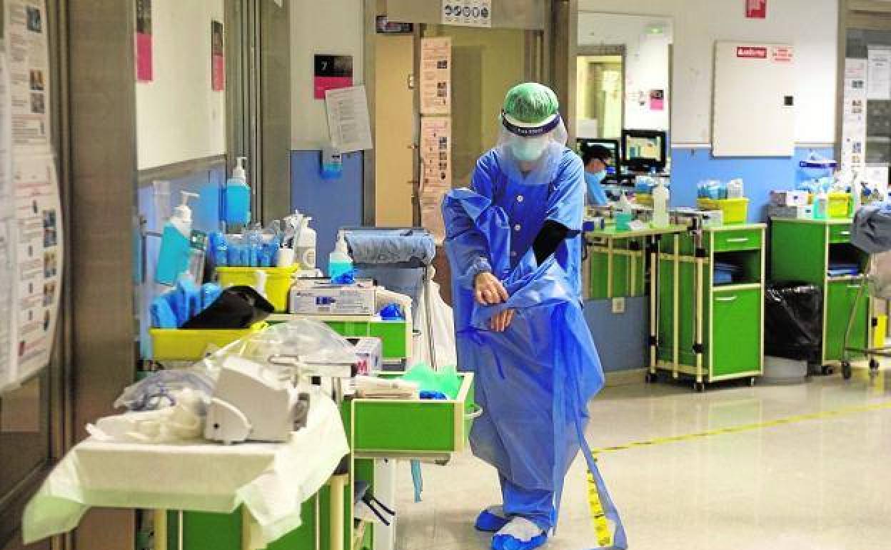 Un sanitario se desprende del equipo de protección en la UCI del Reina Sofía, en una imagen de archivo.