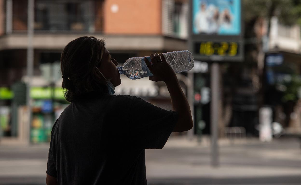 Una mujer bebe agua ante las altas temperaturas.