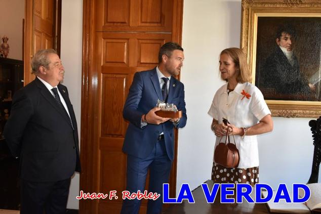 La Infanta Elena fue recibida por el alcalde de Caravaca, José Francisco García, en el Ayuntamiento; saludó a los concejales de la Corporación Municipal y firmó en el libro de honor del consistorio. El regidor caravaqueño entregó a doña Elena una maqueta del castillo-basílica de la Vera Cruz bañada en plata y varios pares de alpargatas de yute fabricadas en una fábrica caravaqueña. La misma que también ha servido este producto artesanal a la Reina Letizia y a Doña Sofía.