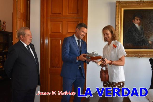 La Infanta Elena fue recibida por el alcalde de Caravaca, José Francisco García, en el Ayuntamiento; saludó a los concejales de la Corporación Municipal y firmó en el libro de honor del consistorio. El regidor caravaqueño entregó a doña Elena una maqueta del castillo-basílica de la Vera Cruz bañada en plata y varios pares de alpargatas de yute fabricadas en una fábrica caravaqueña. La misma que también ha servido este producto artesanal a la Reina Letizia y a Doña Sofía.