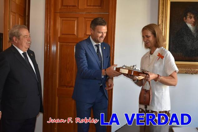 La Infanta Elena fue recibida por el alcalde de Caravaca, José Francisco García, en el Ayuntamiento; saludó a los concejales de la Corporación Municipal y firmó en el libro de honor del consistorio. El regidor caravaqueño entregó a doña Elena una maqueta del castillo-basílica de la Vera Cruz bañada en plata y varios pares de alpargatas de yute fabricadas en una fábrica caravaqueña. La misma que también ha servido este producto artesanal a la Reina Letizia y a Doña Sofía.