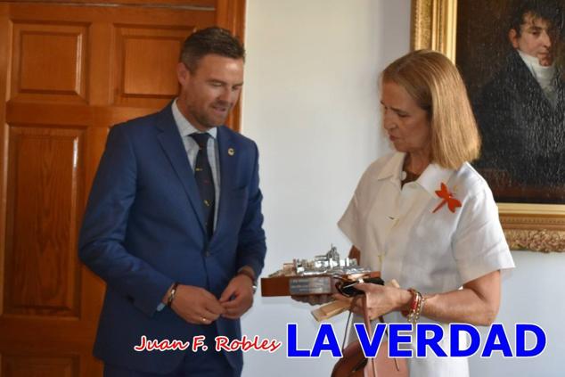 La Infanta Elena fue recibida por el alcalde de Caravaca, José Francisco García, en el Ayuntamiento; saludó a los concejales de la Corporación Municipal y firmó en el libro de honor del consistorio. El regidor caravaqueño entregó a doña Elena una maqueta del castillo-basílica de la Vera Cruz bañada en plata y varios pares de alpargatas de yute fabricadas en una fábrica caravaqueña. La misma que también ha servido este producto artesanal a la Reina Letizia y a Doña Sofía.