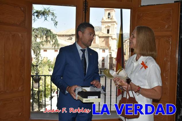 La Infanta Elena fue recibida por el alcalde de Caravaca, José Francisco García, en el Ayuntamiento; saludó a los concejales de la Corporación Municipal y firmó en el libro de honor del consistorio. El regidor caravaqueño entregó a doña Elena una maqueta del castillo-basílica de la Vera Cruz bañada en plata y varios pares de alpargatas de yute fabricadas en una fábrica caravaqueña. La misma que también ha servido este producto artesanal a la Reina Letizia y a Doña Sofía.