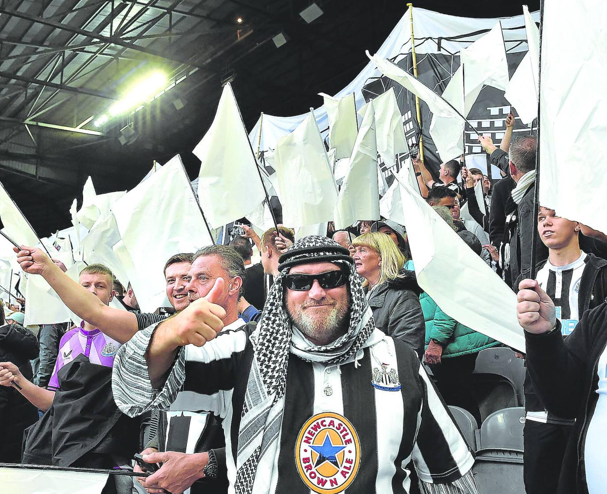 Hinchas del Newcastle celebran la adquisición del equipo de la Premier League por un consorcio saudí liderado por el príncipe heredero Mohamed bin Salmán.