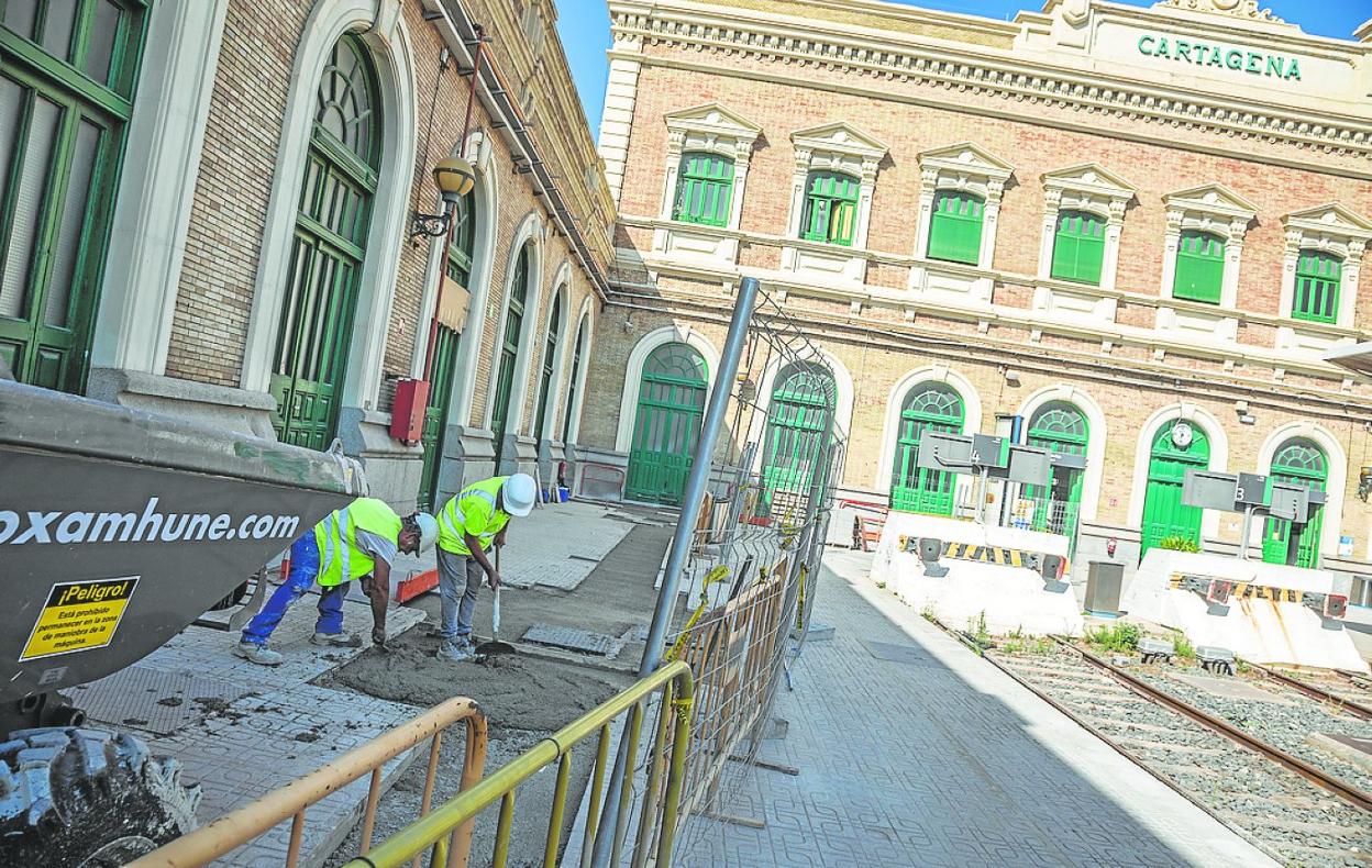 Dos obreros, en plena faena ayer por la mañana junto a uno de los andenes de la terminal de Cartagena.