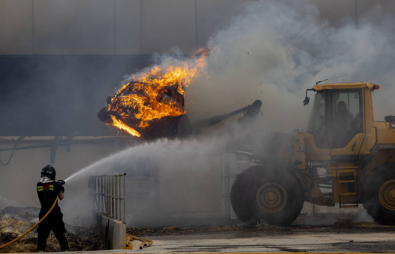 Un bombero durante las labores de extinción del incendio producido en una nave de Pozo Estrecho, este sábado en Cartagena.