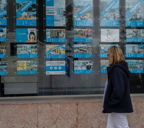 Una mujer observa los anuncios de una inmobiliaria. 