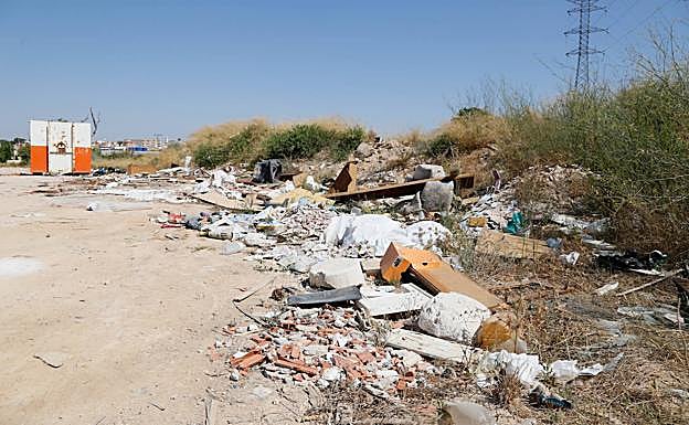 Restos de escombros y un contenedor, en las inmediaciones del centro comercial Mandarache.