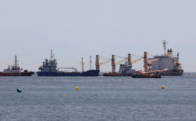 Diversas embarcaciones trabajan junto al buque semihundido en aguas de Gibraltar.